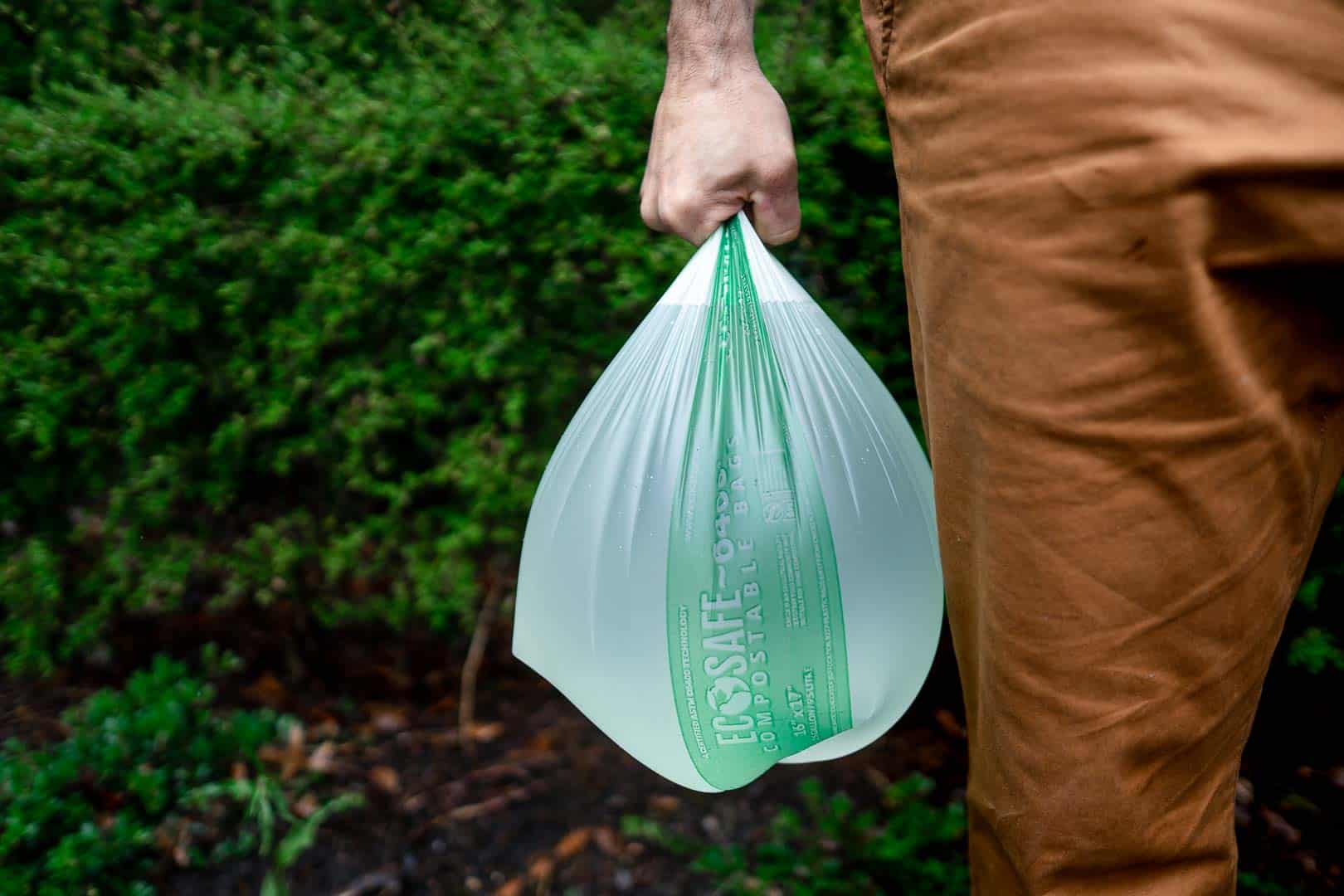Man holding EcoSafe compostable bin bag
