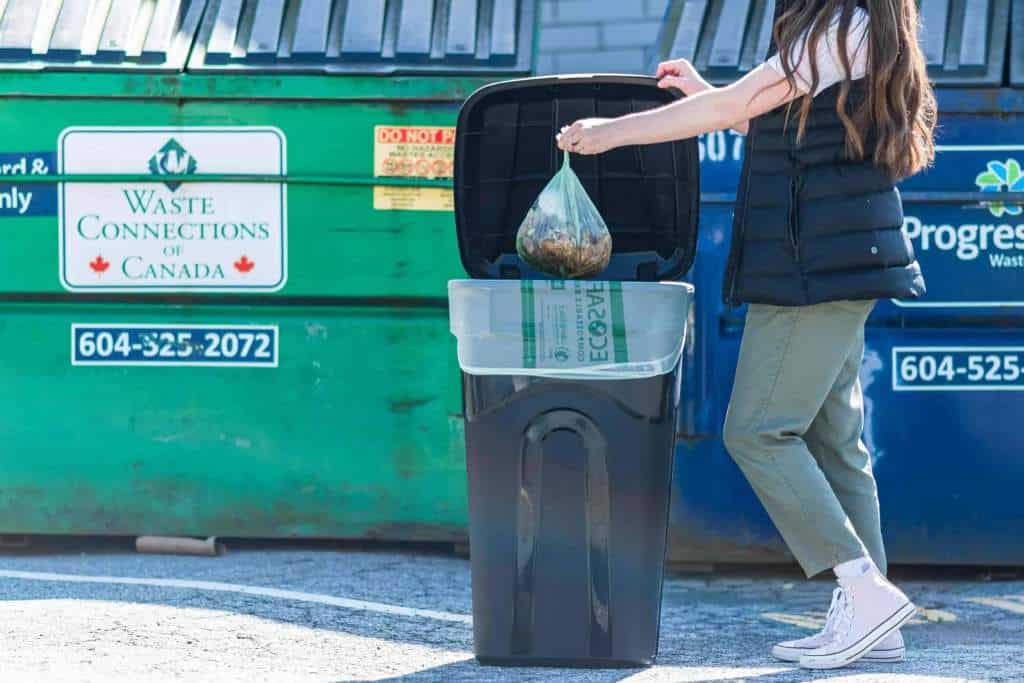 Person putting compostable bag into bin
